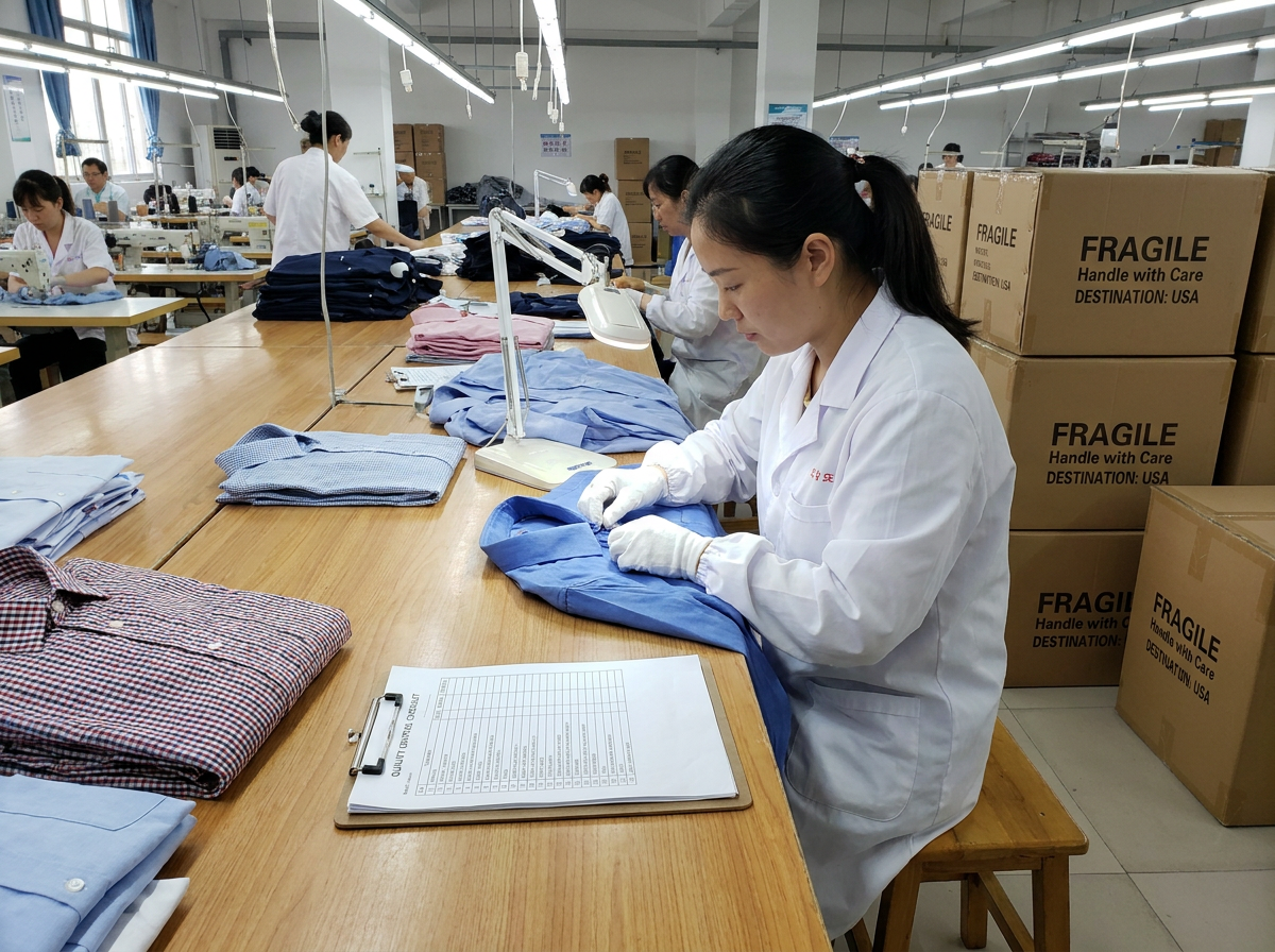 Pre-ship QC inspector checking garments before packing into export cartons