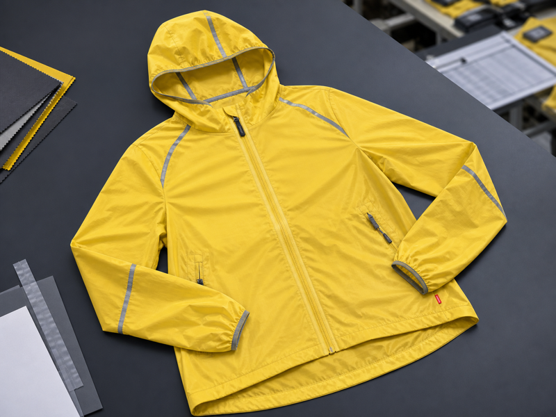 Yellow windbreaker on outdoor trail backdrop
